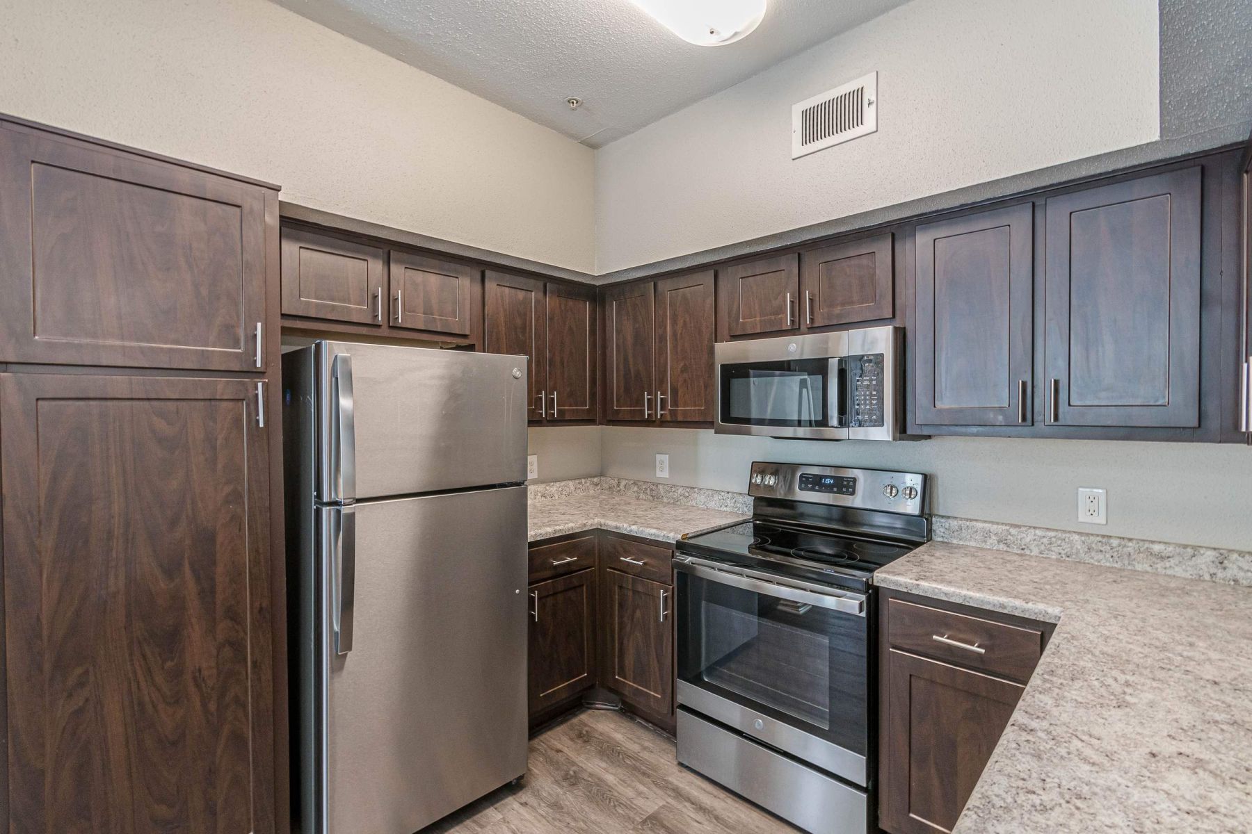 Luxury apartment kitchen with stainless steel appliances, granite countertops, and lots of storage space